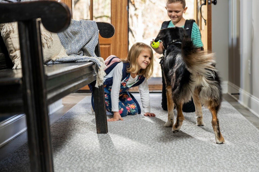 Kids plying with dog on carpet flooring | Boyer’s Floor Covering
